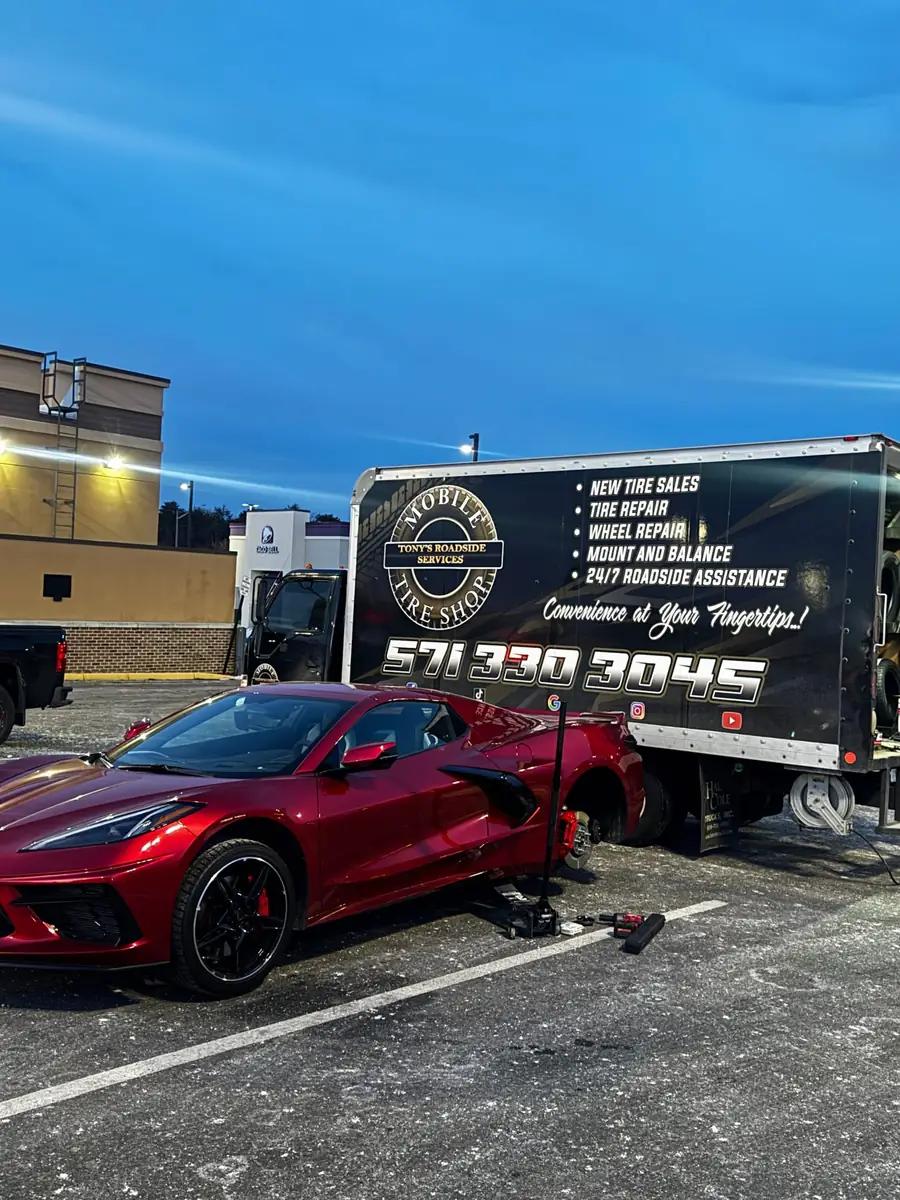 TRS mobile tire service working on a red Corvette in a parking lot